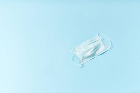 Flatlay with protection mask on blue background. Working from home at the time of coronavirus outbreak conceptの写真素材