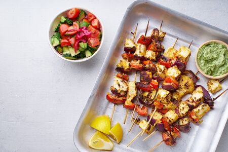 Paneer tikka starter kebabs with mint chutney and chapati. Traditional indian cuisine, grilled cheese skewers with onion and bell pepper slices. Vegetarian dish marinated in tikka sauce.の写真素材