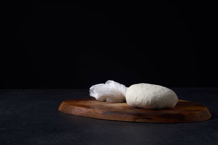 Traditional indian cheese paneer. Cooking vegetarian soft cheese in cheesecloth at home. Dark background, copy spaceの写真素材