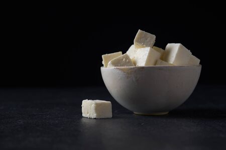 Traditional indian cheese paneer. Vegetarian homemade soft cheese in cheesecloth on dark background.の写真素材
