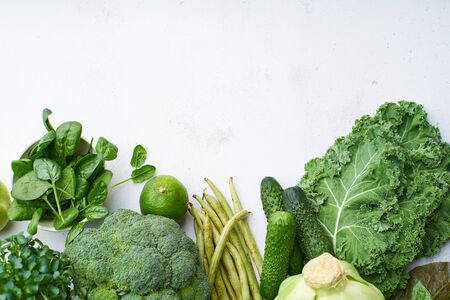 Table with healthy vegetarian meal ingredients. Raw food concept. A variety of organic fruits and vegetables with avocado. Vegan menu, copy space, green color in food.
の写真素材