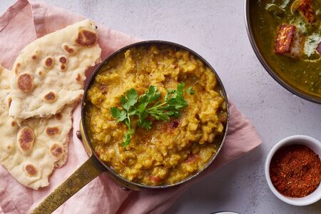 Indian red lentil curry soup dal with rice naan. Vegan indian dish on concrete backgroundの写真素材