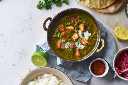 Vegetarian palak paneer starter. Indian cuisine, curry dish with soft cheese and spinach on concrete...