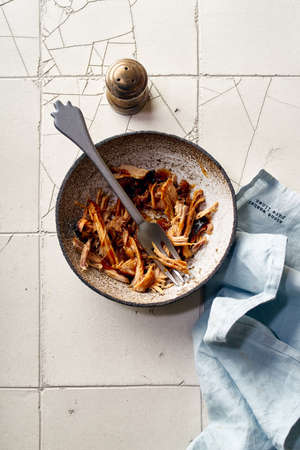 Top view of shredded pulled pork with barbecue sauce in ceramic bowl