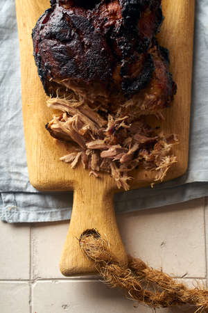 Closeup of glazed pulled pork on wooden cutting board