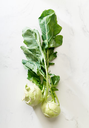 Flat lay with fresh raw kohlrabi on white background. New ideas for vegetarian cuisine conceptの写真素材
