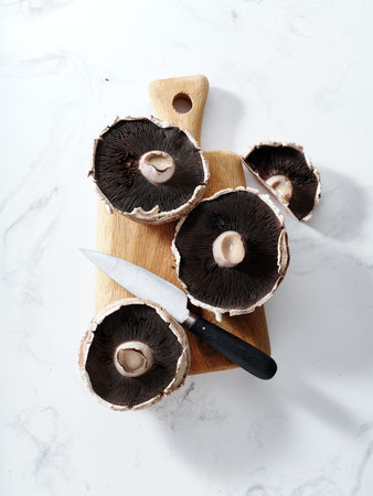 Top view various mushrooms on a wooden cutting board: portobello, champignons, chanterellesの写真素材