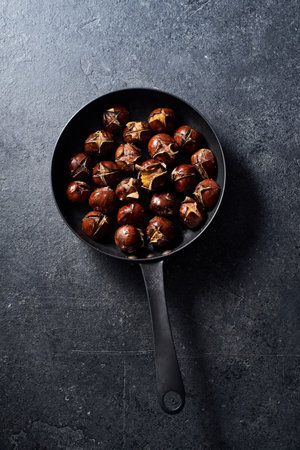 Top view of roasted chestnuts in a frying pan.の写真素材