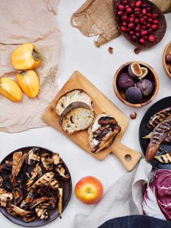 Flat lay seasonal vegetables, fruits and bread, healthy vegetarian ingredients. Grilled aubergines and mushroomsの写真素材