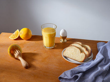 Breakfast with a glass of fresh-pressed orange juice and some slices of brioche breadの写真素材
