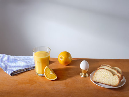 Breakfast with a glass of fresh-pressed orange juice and some slices of brioche breadの写真素材