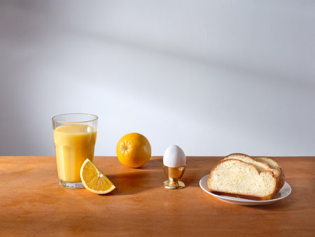 Breakfast with a glass of fresh-pressed orange juice and some slices of brioche breadの写真素材