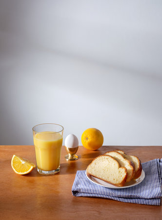 Breakfast with a glass of fresh-pressed orange juice and some slices of brioche breadの写真素材