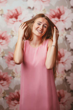 girl in a pink dress on a colored background with different emotionsの写真素材