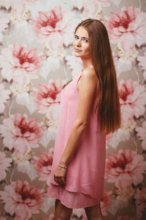 girl in a pink dress on a colored background with different emotionsの写真素材