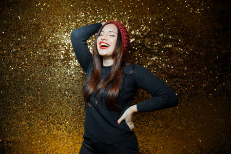 women dressed black having fun in night clubs photographed on gold background girl have black scarf with stars them red lipstick and they are very funnyの写真素材