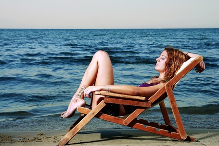 girl at the beach sitting in chairの写真素材