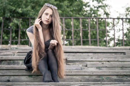 portrait of a beautiful young sad hipster girl  outdoors at the day timeの写真素材