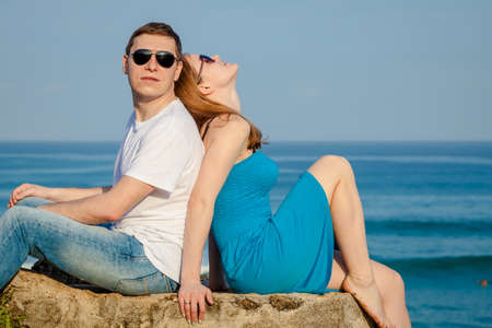 Loving couple sitting on the beach at the day time. Concept of friendly family.の写真素材