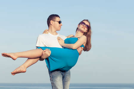 Loving couple standing on the beach at the day time. Concept of friendly family.