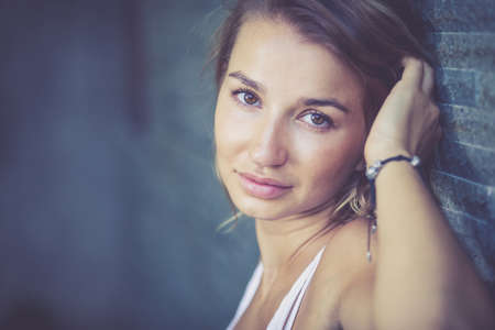 portrait of a beautiful blonde girl near the wallの写真素材