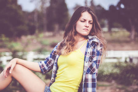 Sad Trendy Hipster Girl Relaxing on the road at the day time. Concept of Modern Youth Lifestyle .の写真素材