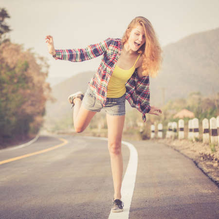 Trendy Hipster Girl Relaxing on the road at the day time. Concept of Modern Youth Lifestyle .の写真素材
