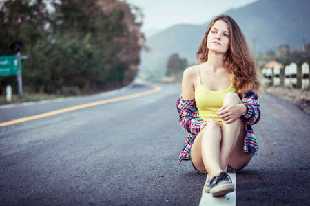 Trendy Hipster Girl Relaxing on the road at the day time. Concept of Modern Youth Lifestyle .の写真素材