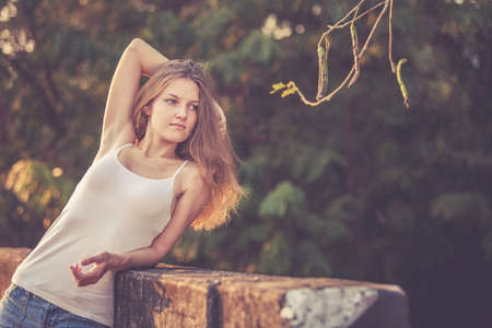 Trendy Hipster Girl Relaxing on the road at the day time. Concept of Modern Youth Lifestyle .