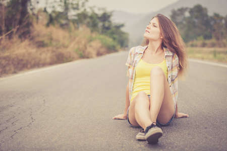Trendy Hipster Girl Relaxing on the road at the day time. Concept of Modern Youth Lifestyle .の写真素材
