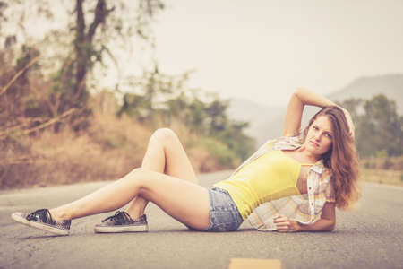 Trendy Hipster Girl Relaxing on the road at the day time. Concept of Modern Youth Lifestyle .の写真素材