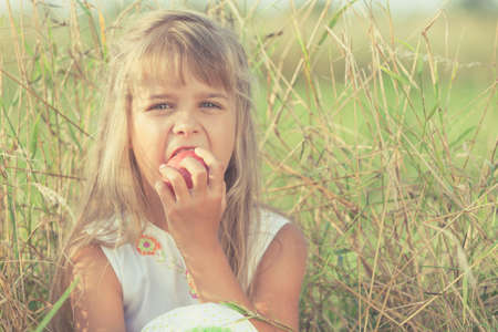 One happy little girl playing in park at the day time. Child having fun on the nature. Concept of happiness.の写真素材