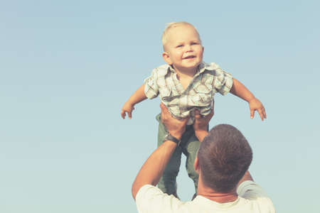 Happy family playing in park at the day time. Father and son having fun on the nature. Concept of happiness.の写真素材