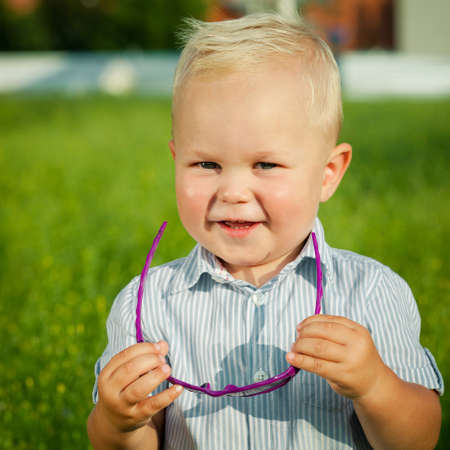 One happy little boy playing in park at the day time. Child having fun on the nature. Concept of...