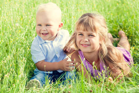 Happy brother and sister playing in park at the day time. People having fun on the nature. Concept of happiness.の写真素材