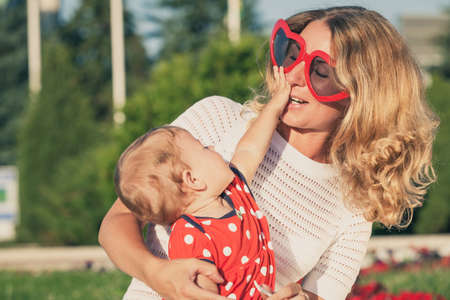 Happy mother and daughter playing in park at the day time. People having fun on the nature. Concept of happiness.の写真素材