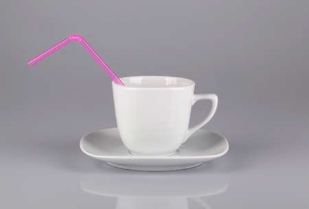 Coffee cup with a pink straw isolated over white background