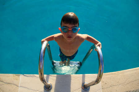 little boy on the pool stairsの写真素材