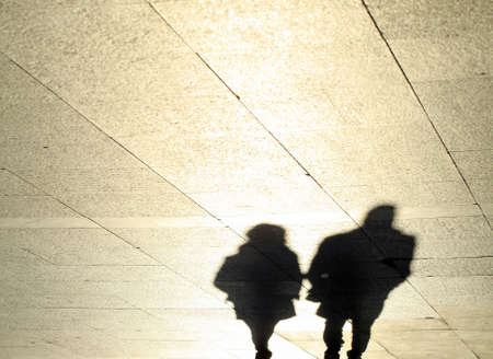 shadows of a couple reflected on the sidewalk