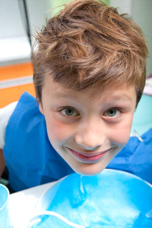 Young boy drinking water after dental operationの写真素材