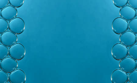 macro bubbles in water illuminated by a beam of light on a blue background
