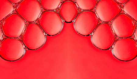 macro bubbles in water illuminated by a beam of light on a red background