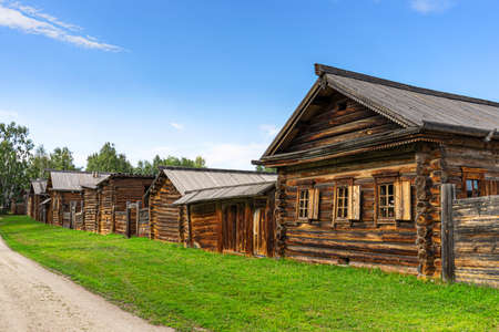 A wooden huts on the street of the Siberian village at summer. Architectural ethnographic Museum Taltsy on the shore of the Angara river near lake Baikalの写真素材