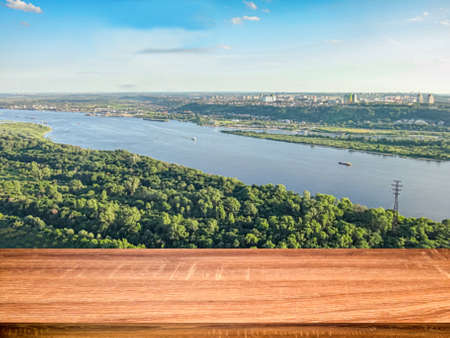 Empty wooden table with blurred background of aerial view of the Volga river and the Nizhny Novgorod city. Can be used for display or montage productsの写真素材