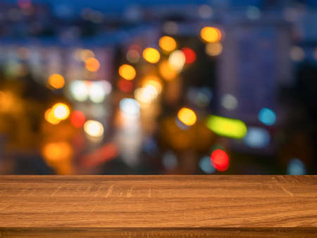 Empty wooden table with abstract background of night city. Can be used for display or montage...