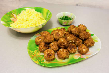 Fried meatballs with mashed potatoes and fresh herbs on a tableの写真素材
