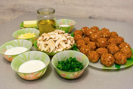 Ingredients for cooking meatballs with stroganoff gravy: minced meat, mushrooms, onion, garlic, butter, sour cream, heavy cream, broth, flour, fresh herbsの写真素材