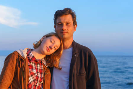 Portraits of father and daughter in the summer at sunset on the shore of lake Baikalの写真素材