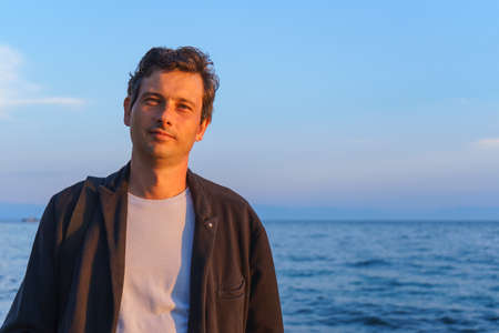 Portrait of a middle aged man in the summer at sunset on the shore of lake Baikalの写真素材