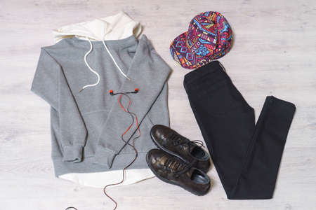 Teen clothing set: grey sweatshirt, black jeans, boots in military style and colored cap